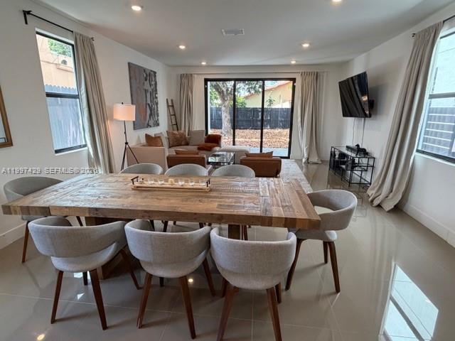 A dining area with a wooden table and chairs opens into a living room space — 3645 SW 3 st, Miami FL 33135, MIAMI, FL
