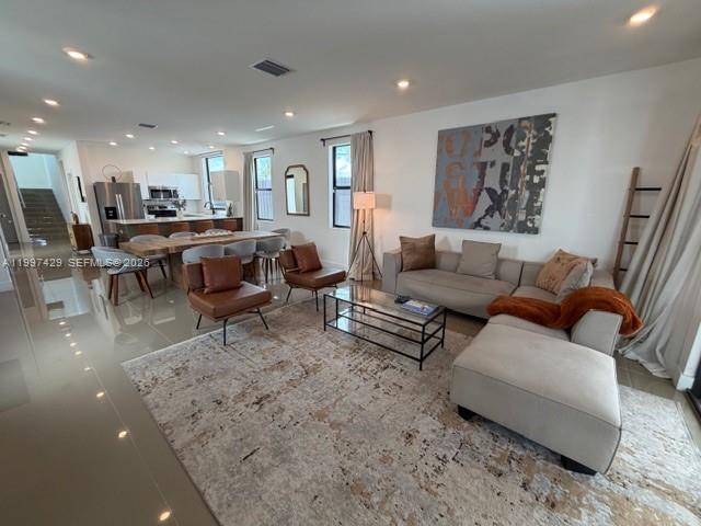 An open-concept living and dining area features tile flooring, neutral furniture, and modern lighting — 3645 SW 3 st, Miami FL 33135, MIAMI, FL