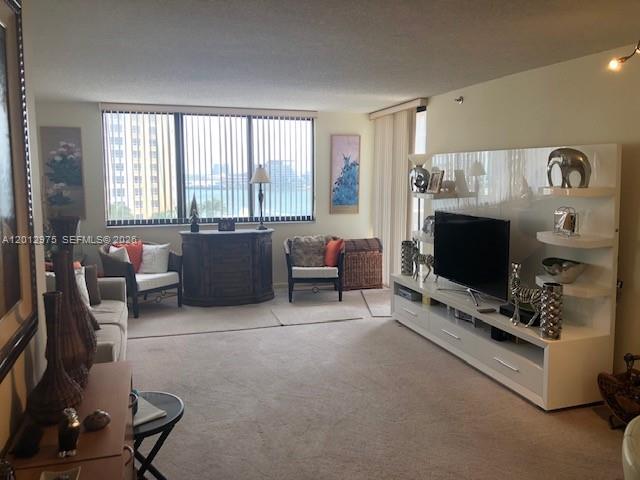 A living room features a large entertainment center, a window with vertical blinds, and furniture — 540 Brickell Key Dr # 1116, Miami FL 33131, MIAMI, FL