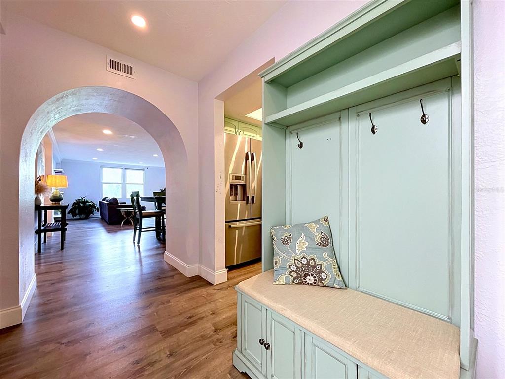 A light green mudroom bench sits in a hallway leading to an arched living area — 4651 1ST STREET NE UNIT 311, ST PETERSBURG, FL
