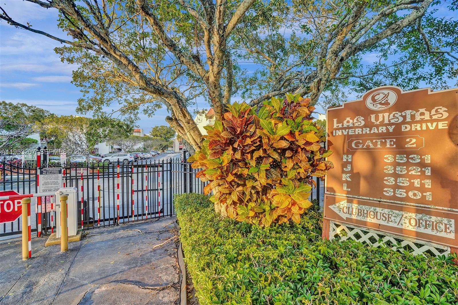 A sign for Las Vistas at Inverrary Drive stands beside a gated entrance and trees — 3511 E Inverrary Dr # 107, Lauderhill FL 33319, LAUDERHILL, FL