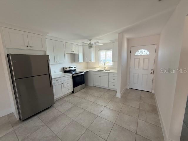 A kitchen features white cabinets, stainless steel appliances, and light-colored tile flooring — 747 SAINT JUDES DRIVE S UNIT 2, LONGBOAT KEY, FL