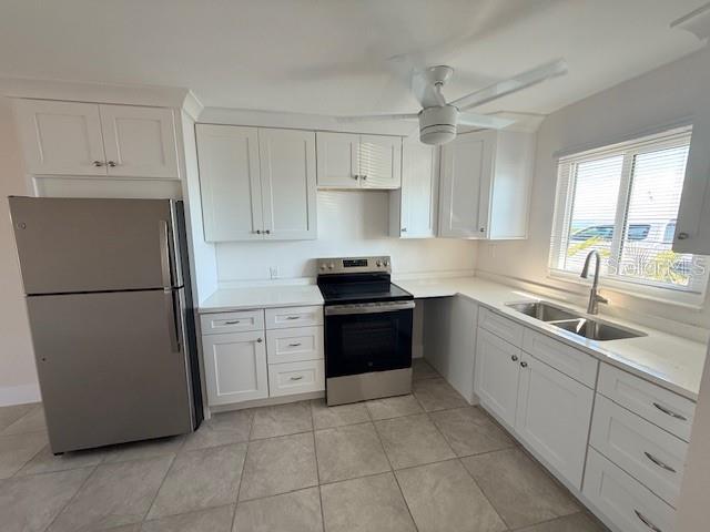 A kitchen features white cabinets, stainless steel appliances, and tile flooring — 747 SAINT JUDES DRIVE S UNIT 2, LONGBOAT KEY, FL