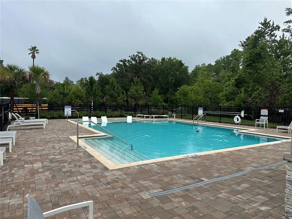 A rectangular swimming pool with a tanning ledge is surrounded by a brick paver deck — 2511 BRIGHT JEWEL STREET, KISSIMMEE, FL