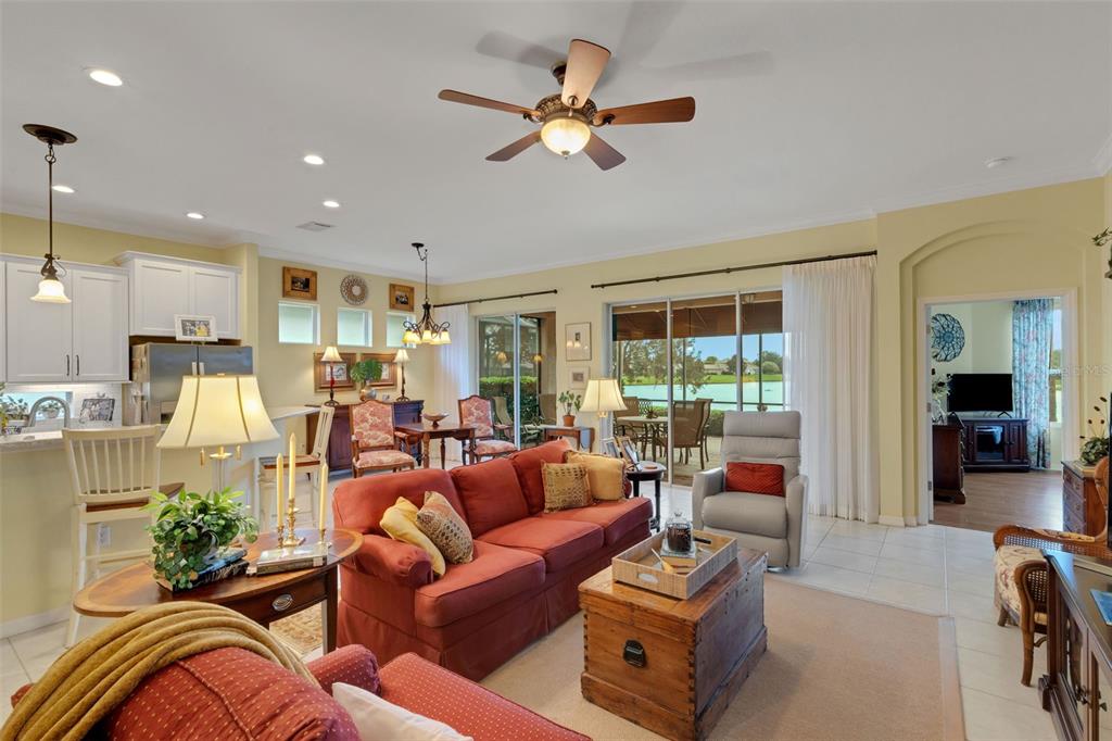 A living room with a red sofa, wooden coffee table, and sliding doors to a patio — 2530 LAUREL GLEN DRIVE, LAKELAND, FL