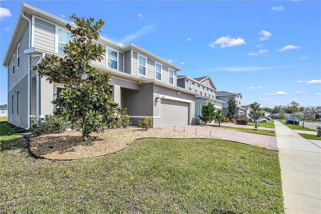 A two-story suburban house with a gray exterior, a paved driveway, and a front lawn — 3005 SLOUGH CREEK DRIVE, KISSIMMEE, FL