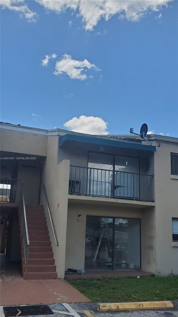A two-story apartment building exterior features a staircase, a balcony, and sliding glass doors — 7405 SW 152nd Ave # 3, Miami FL 33193, MIAMI, FL
