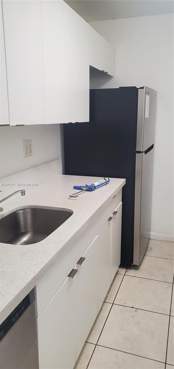 A kitchen features white cabinets, a stainless steel sink, and a black and silver refrigerator — 7405 SW 152nd Ave # 3, Miami FL 33193, MIAMI, FL
