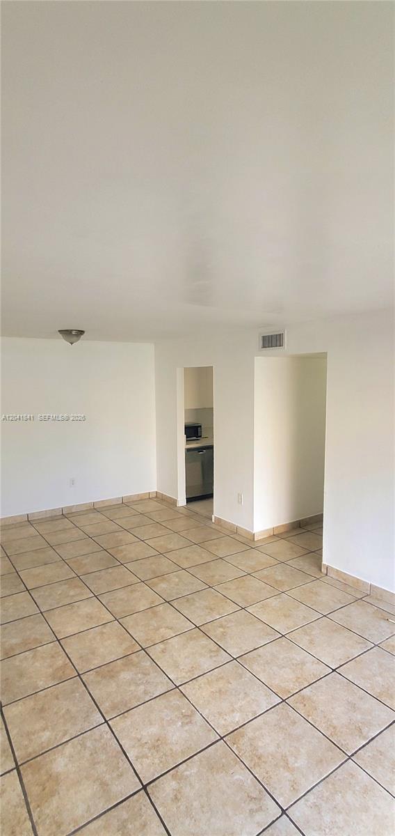 An empty room features light-colored square floor tiles and white walls with two doorways — 7405 SW 152nd Ave # 3, Miami FL 33193, MIAMI, FL
