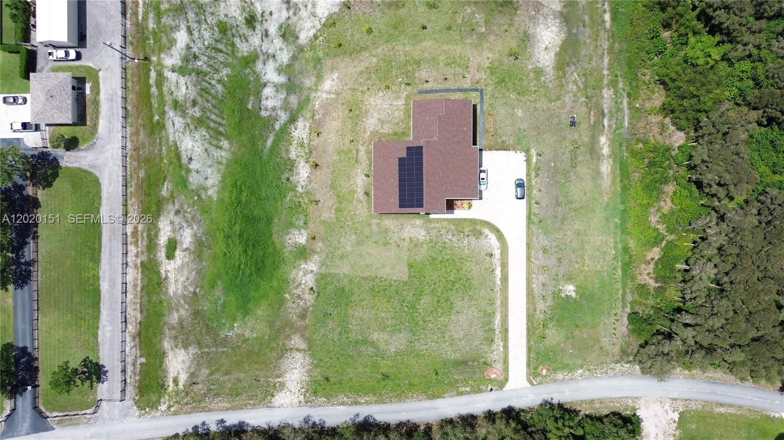 An aerial view shows a house with solar panels on a large, grassy lot — 19860 Skyhawk Ln, Loxahatchee FL 33470, LOXAHATCHEE, FL