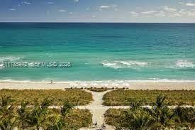 An outdoor swimming pool and hot tub are surrounded by a brick patio and landscaping — 8855 Collins Ave # 9E, Surfside FL 33154, SURFSIDE, FL