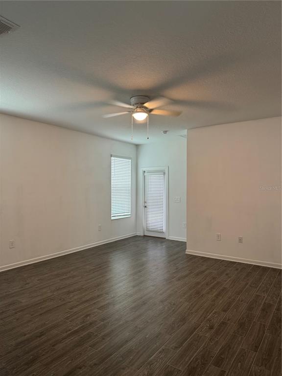 An empty room with wood-look tile flooring, a ceiling fan, and a glass-paneled door — 1652 CROSS PRAIRIE PARKWAY, KISSIMMEE, FL