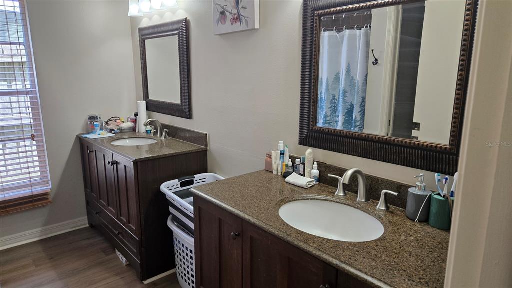 A bedroom features a dark wood storage bed, two nightstands, and a sliding glass door — 9765 FOX CHAPEL ROAD, TAMPA, FL