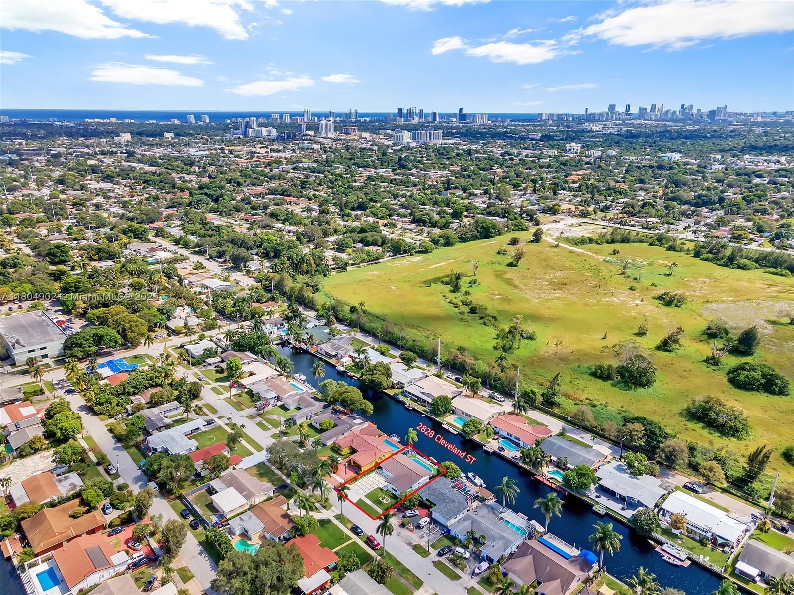 An aerial view shows a residential house with a pool situated along a canal — 2828 Cleveland St, Hollywood FL 33020, HOLLYWOOD, FL