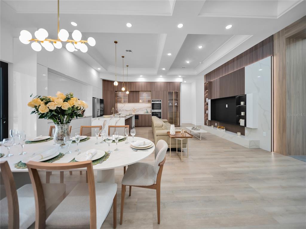 An open-concept living and dining area features modern wood cabinetry, marble surfaces, and recessed lighting — 11241 OSWALT ROAD, CLERMONT, FL