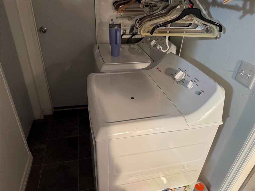 A laundry room features two white Hotpoint appliances and a rack of hanging clothes — 18110 SPANGLER AVENUE, BROOKSVILLE, FL