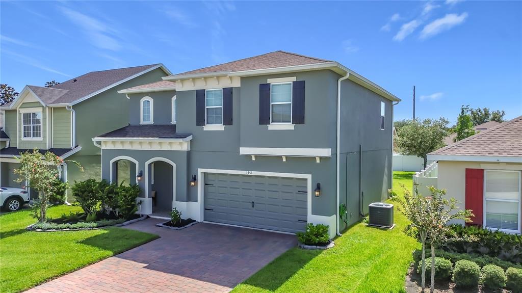 A two-story house with a gray exterior, a two-car garage, and a paved driveway — 1553 CATERPILLAR STREET, ST CLOUD, FL