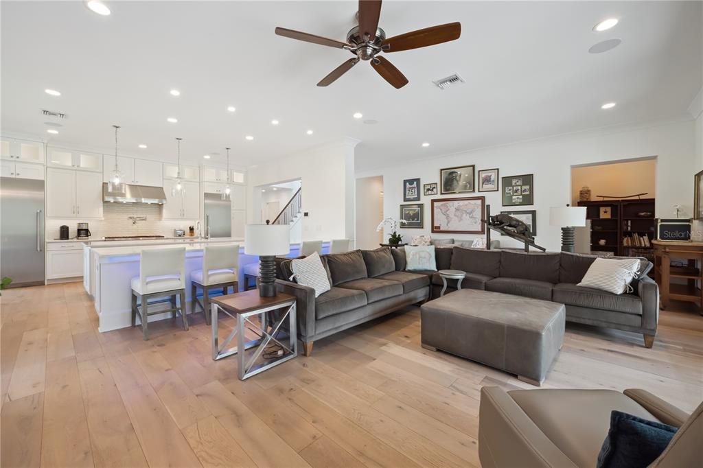 An open-concept kitchen and living area features white cabinetry, a large island, and gray furniture — 11539 LAKE BUTLER BOULEVARD, WINDERMERE, FL