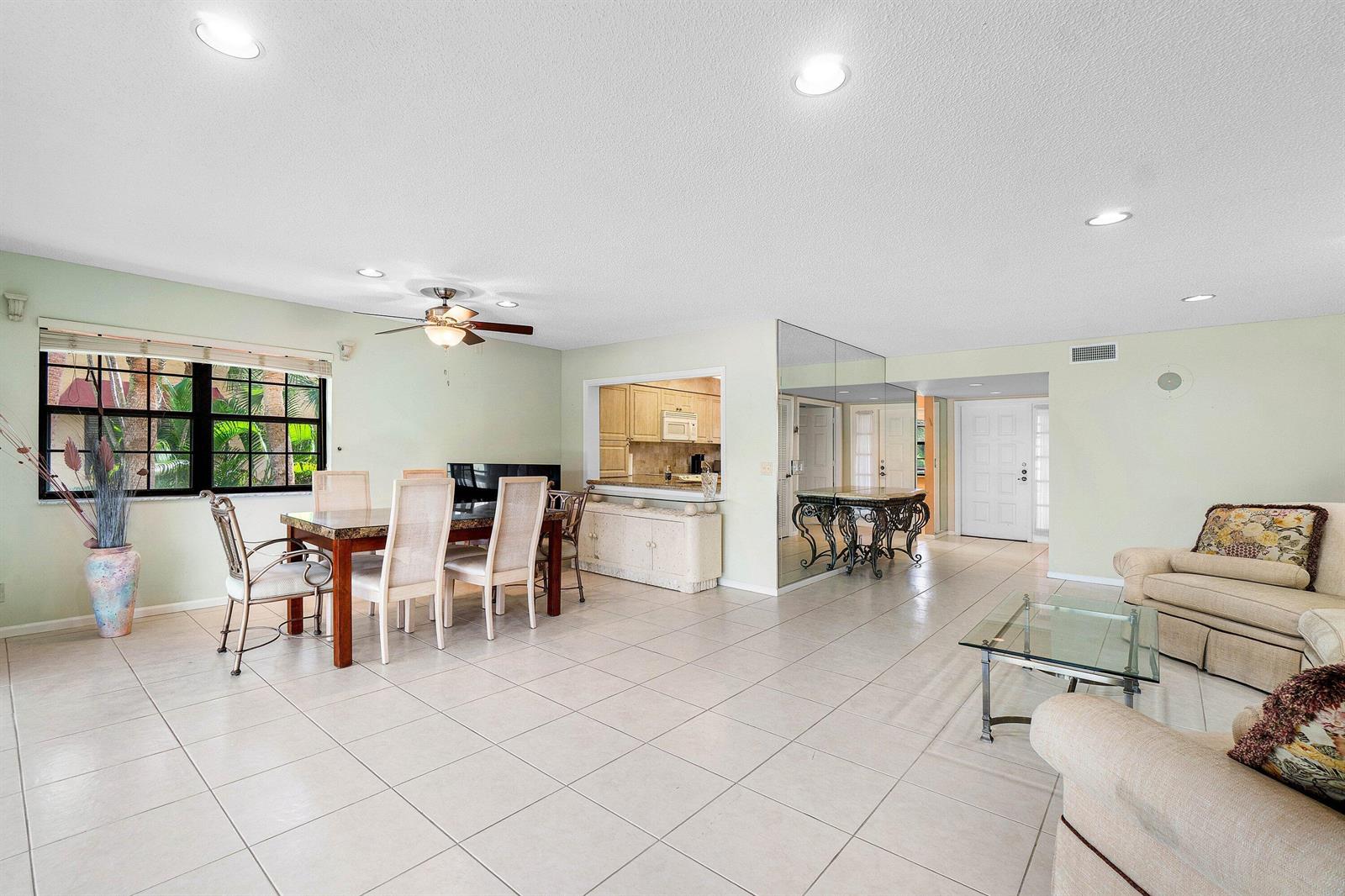 A dining and living area features tile floors, a ceiling fan, and a kitchen pass-through — 6446 Aspen Glen Circle, Boynton Beach FL 33437, BOYNTON BEACH, FL