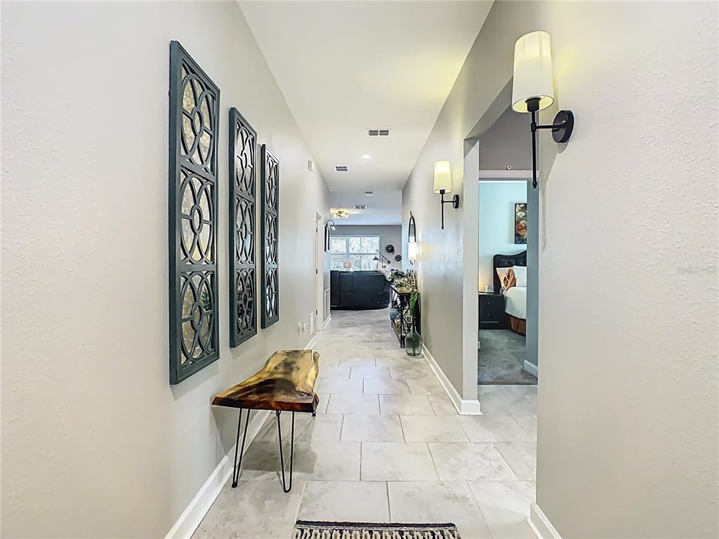 A hallway features light tile flooring, wall sconces, and a live-edge wood bench — 1055 OAK BLUFF DRIVE, DAVENPORT, FL