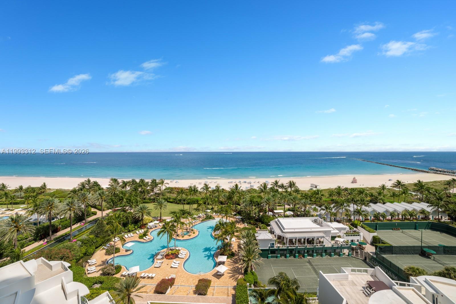 An aerial view shows a swimming pool, tennis courts, and palm trees overlooking the ocean — 100 S Pointe Dr, Miami Beach FL 33139, MIAMI BEACH, FL