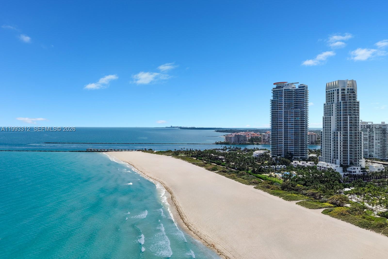 An aerial view shows a sandy beach, turquoise ocean, and two tall residential towers — 100 S Pointe Dr, Miami Beach FL 33139, MIAMI BEACH, FL