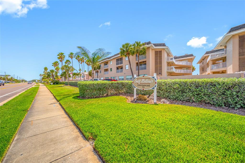 A sidewalk runs alongside a grassy lawn in front of the Gulf Belleair Condominiums building — 3100 GULF BOULEVARD UNIT 132, BELLEAIR BEACH, FL