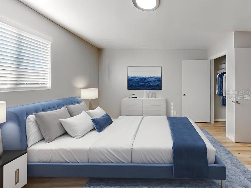This is a virtually staged bedroom featuring a blue upholstered bed and a white dresser — 4701 31ST STREET S UNIT B2, ST PETERSBURG, FL