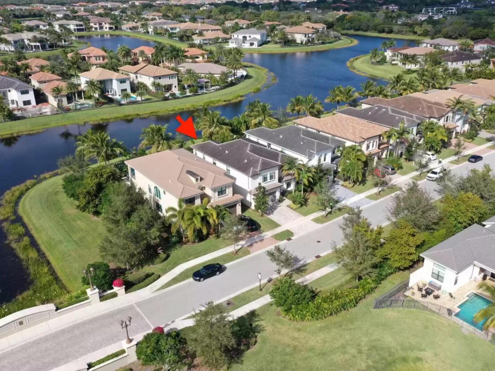 An aerial view shows a suburban neighborhood with houses along a winding canal — 16645 Germaine Drive, Delray Beach FL 33446, DELRAY BEACH, FL