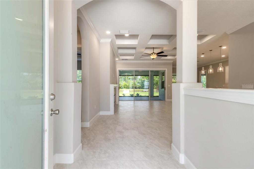 A view from an entryway looking into a living room with a coffered ceiling — 61 N RIVERWALK DRIVE, PALM COAST, FL