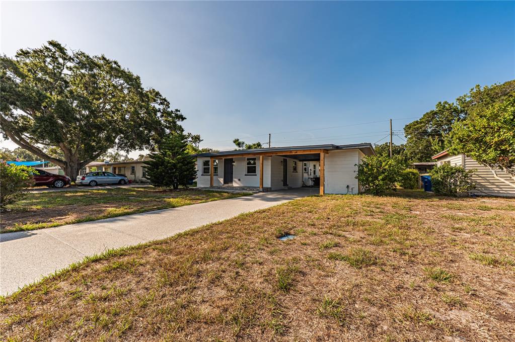 A single-story house with a white exterior, a covered carport, and a concrete driveway — 1359 BARRY STREET, CLEARWATER, FL