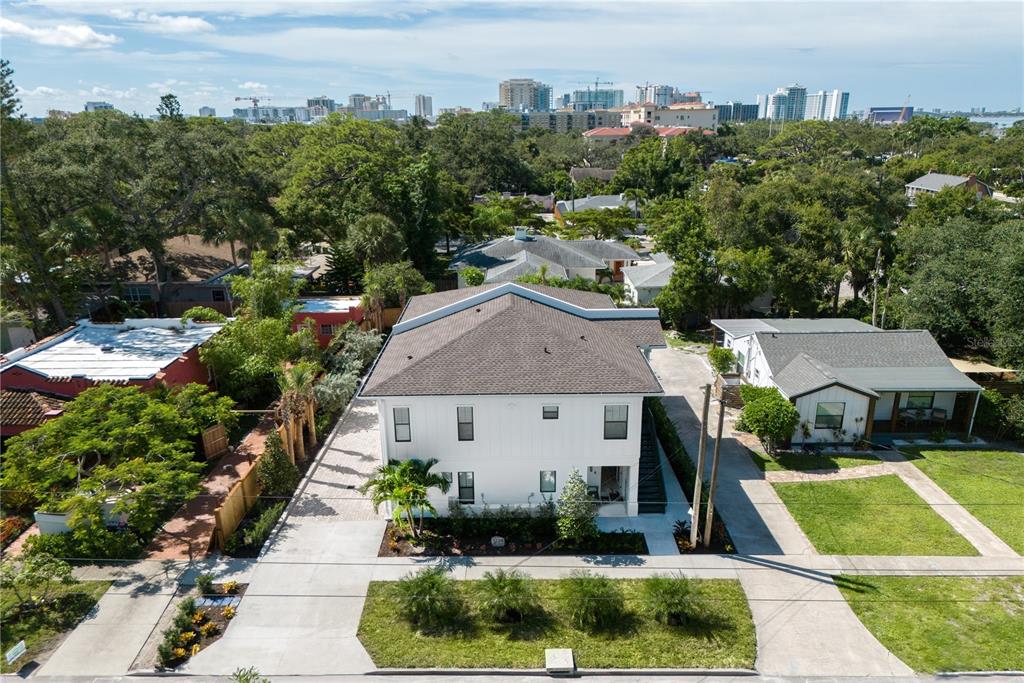 An aerial view shows a two-story white house with a gray roof and surrounding landscaping — 1234 15TH STREET UNIT 102, SARASOTA, FL