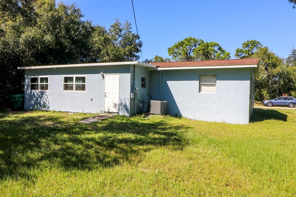 A light blue, single-story house with a brown roof sits on a grassy lot — 3580 SWANEE ROAD, PORT CHARLOTTE, FL
