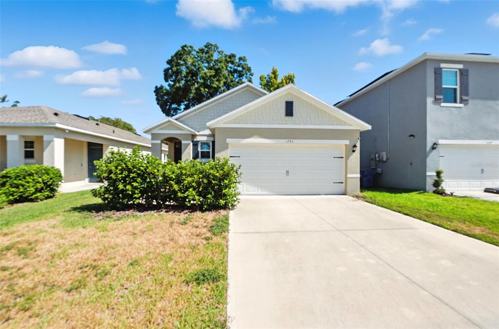 A single-story suburban house with a white garage door and a concrete driveway — 1753 BENT BRANCH AVENUE, DELAND, FL