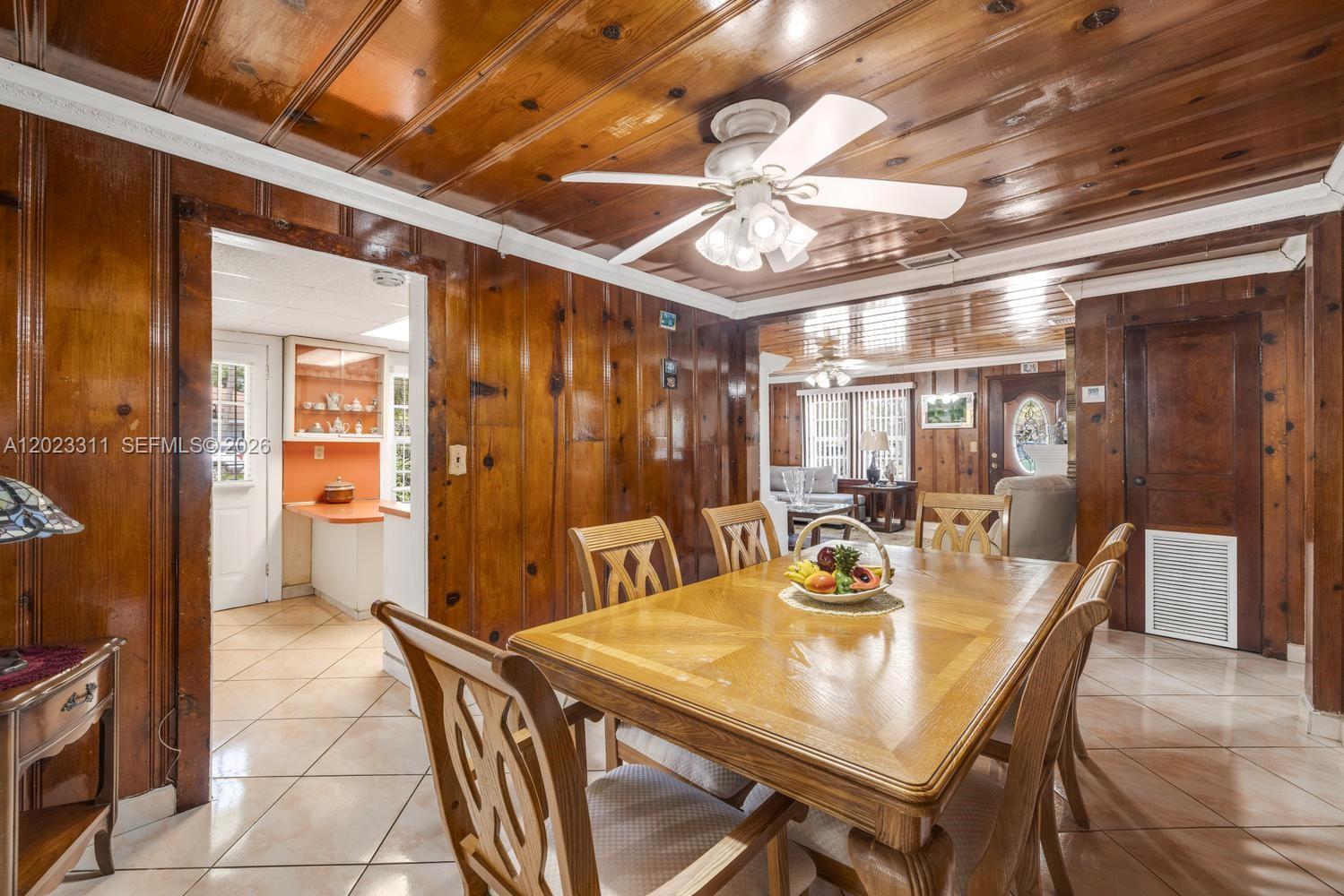 A dining room features wood-paneled walls, a wood ceiling, and a wooden table with chairs — 2851 NW 106th St, Miami FL 33147, MIAMI, FL