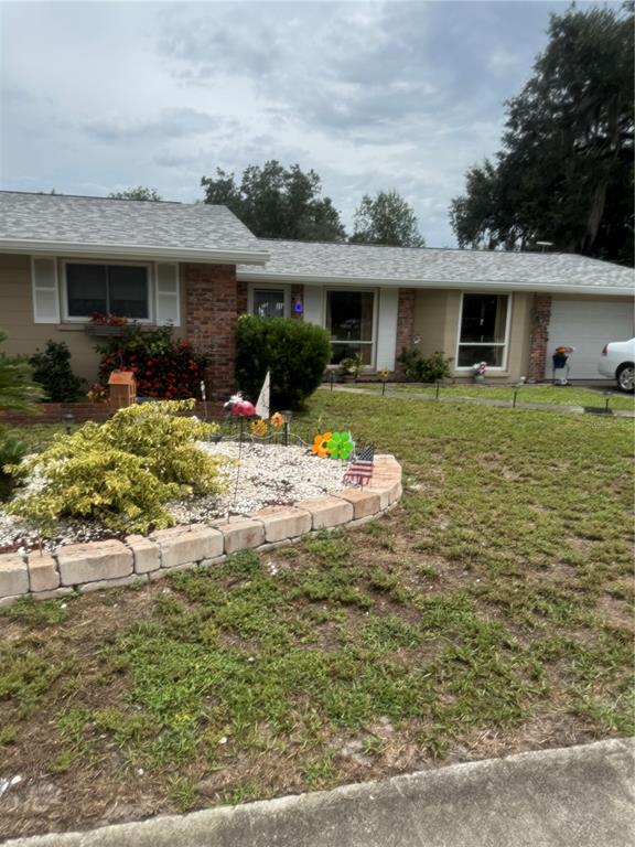 A single-story house with a brick facade, light-colored siding, and a landscaped front yard — 722 W WHIDDEN STREET, ARCADIA, FL