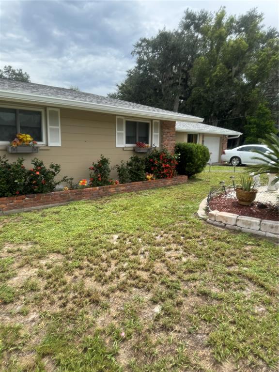 A tan house with a brick planter box and a white car in the driveway — 722 W WHIDDEN STREET, ARCADIA, FL