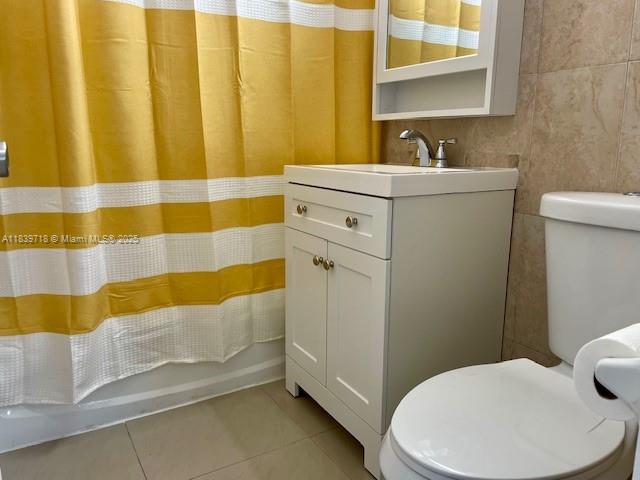 A bathroom features a white vanity, a toilet, and a yellow and white shower curtain — 330 W 40th Pl, Hialeah FL 33012, HIALEAH, FL