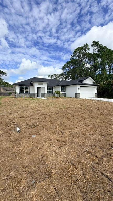 A newly constructed white single-story house with a dark roof and a large dirt yard — 1217 E PRICE BOULEVARD, NORTH PORT, FL