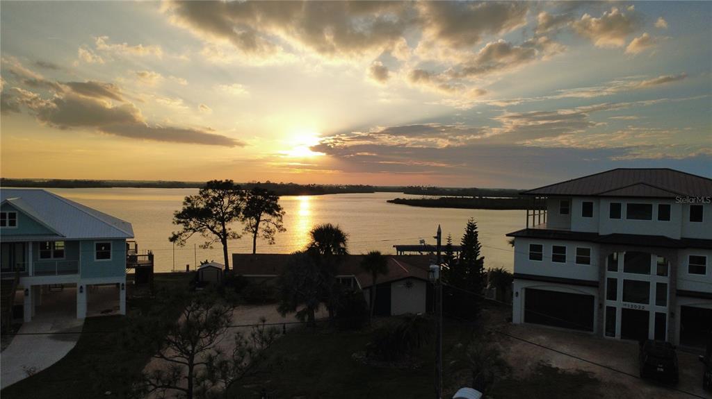 An elevated view of two waterfront houses at sunset overlooking a calm bay — 11999 W BAYSHORE DRIVE, CRYSTAL RIVER, FL
