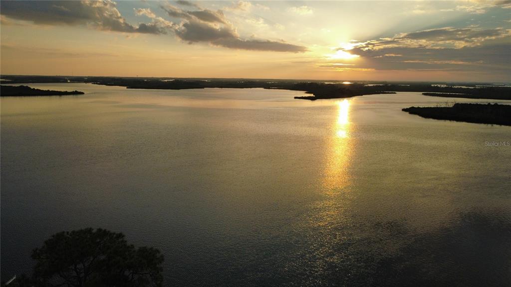 An aerial view of a large lake at sunset with distant treelined shores — 11999 W BAYSHORE DRIVE, CRYSTAL RIVER, FL