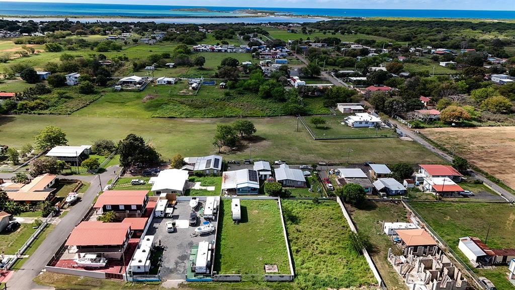 An aerial view shows a coastal neighborhood with houses, vacant lots, and parked boats — CARR 3301 W COMBATE, CABO ROJO, PR