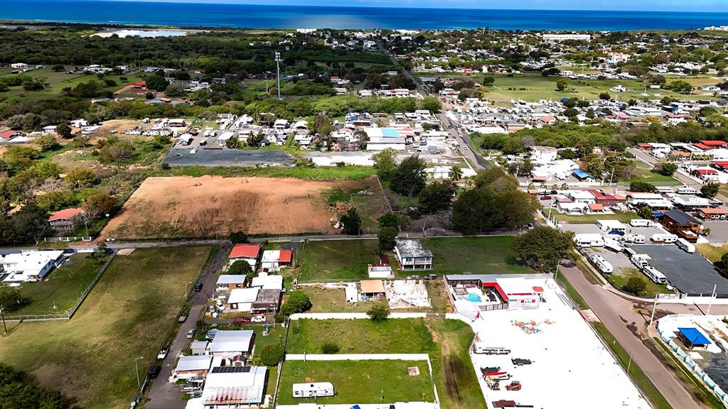 An aerial view shows a coastal town with residential buildings, open lots, and a large parking area — CARR 3301 W COMBATE, CABO ROJO, PR