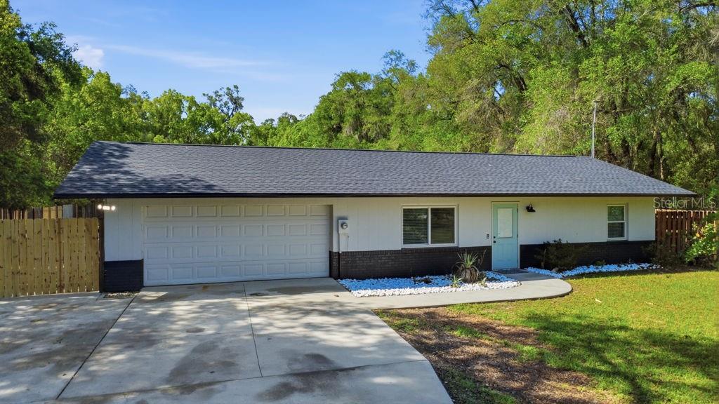 A single-story house with a white exterior, dark brick base, and a two-car garage — 550 E MINNESOTA AVENUE, ORANGE CITY, FL