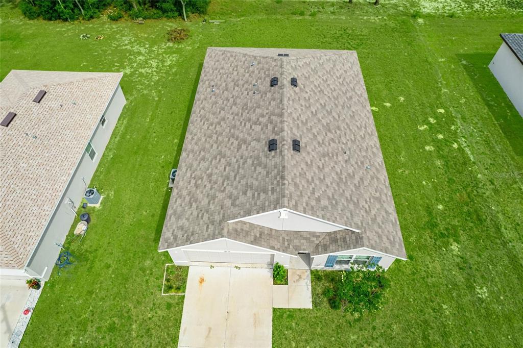 An aerial view shows the shingled roof of a suburban house with a concrete driveway — 14944 SW 66TH AVENUE ROAD, OCALA, FL