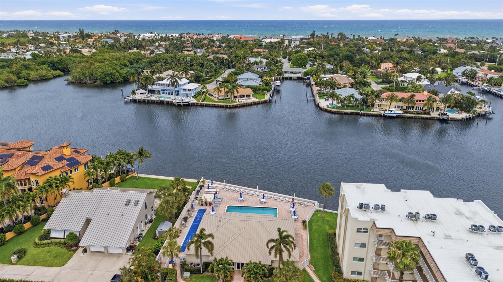 An aerial view shows a waterfront property with a pool, patio, and surrounding homes — 600 Snug Harbor Drive # A10, Boynton Beach FL 33435, BOYNTON BEACH, FL