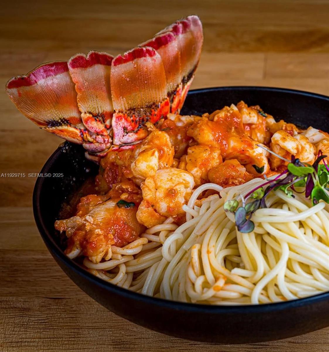 A bowl of pasta topped with lobster meat and a lobster tail garnish — 2491 SW 147, Miami FL 33185, MIAMI, FL