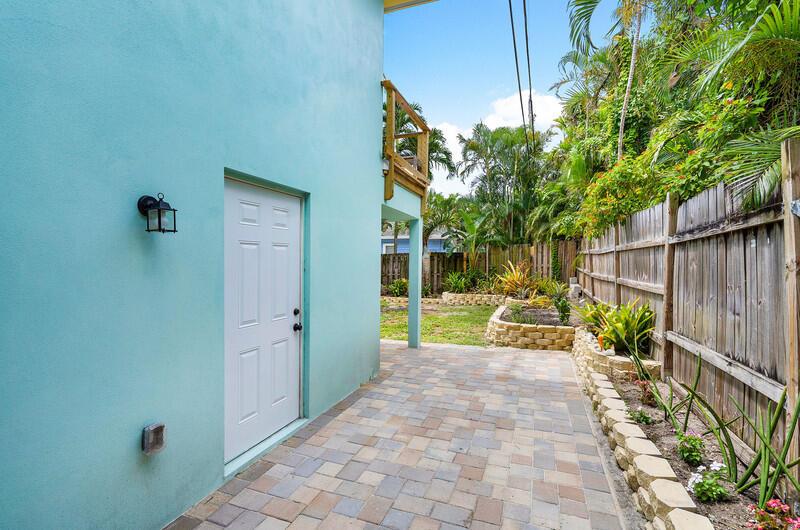 A paved patio area sits beside a light blue house with a white door and fence — 300 SE 7th Avenue, Delray Beach FL 33483, DELRAY BEACH, FL