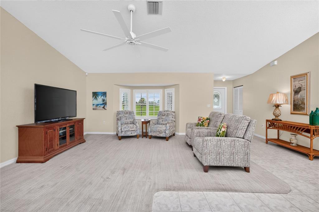 A living room features a television console, two armchairs, a loveseat, and a bay window — 31 MEADOWLARK LANE, PLACIDA, FL