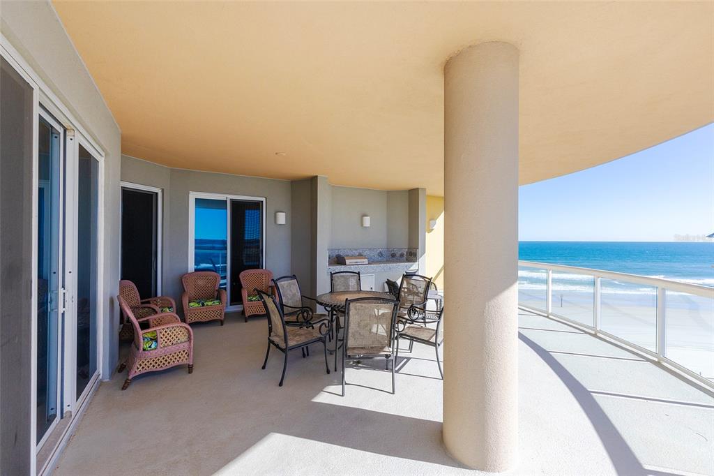 A spacious, covered balcony features outdoor furniture, a built-in grill, and ocean views — 3703 S ATLANTIC AVENUE UNIT 505, DAYTONA BEACH SHORES, FL